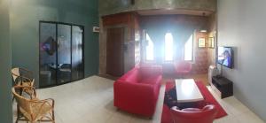 怡保Andak Home2stay的客厅配有红色的沙发和椅子