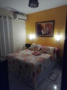 雅克南Pousada Kamaka Praia的小卧室配有一张带鲜花毯子的床