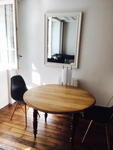 巴黎Chez Vous ST HONORÉ的一张桌子,房间内设有镜子和椅子