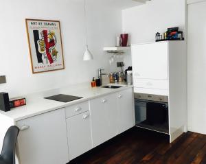 巴黎Chez Vous ST HONORÉ的厨房配有白色橱柜和黑色用具