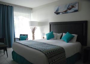 哥西尔Hotel Fleur d'Epee - Plage de Bas du Fort的一间卧室配有一张带蓝色枕头的大床