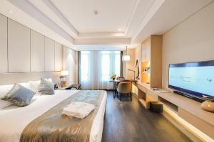 无锡无锡盛捷圆融广场服务公寓的一间酒店客房,配有一张大床和一台平面电视