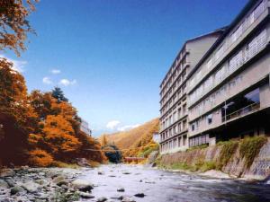 福岛Itoen Hotel Iizakakanouya的毗邻建筑物的河流