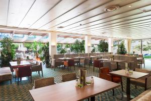 德弗雷根谷地圣雅各布阿尔卑霍夫酒店的餐厅设有桌椅和窗户。