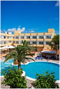 卡拉布兰卡Sagitario Playa的拥有棕榈树和游泳池的大型酒店