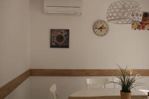 托莱多Apartamentos Homelife Roca Tarpeya的一间设有桌子和墙上时钟的餐厅