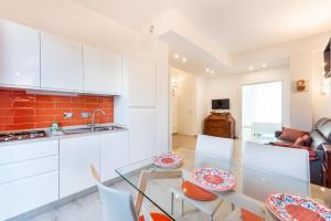 佛罗伦萨Modern Flat Alberti Arno River Lift & Terraces的厨房配有白色橱柜和玻璃桌