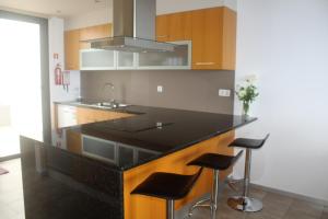 阿科达卡列塔Villa Girasol的厨房配有黑色台面和凳子