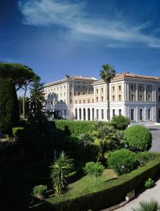 罗马TH Roma - Carpegna Palace的一座大建筑,前面设有花园