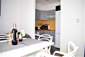雷布尼克Apartament Fibra Cortado的白色的厨房配有桌子和白色椅子