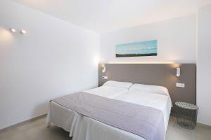 科斯塔特吉塞瑟乐特旅馆的卧室配有白色的床和墙上的绘画作品