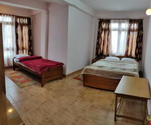 噶伦堡Deki Lodge的一间卧室配有两张床,内设长凳