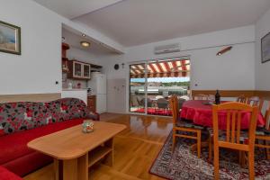 马卡尔斯卡Apartments Roza的客厅配有红色的沙发和桌子