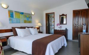 萨格里什君悦胡里奥酒店的一间卧室配有一张床、梳妆台和镜子