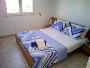 丽都玛里尼Residence Sabbiachiara的一间卧室配有一张带蓝色和白色枕头的床