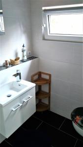 德伯尔恩Bungalow Thiele的白色的浴室设有水槽和窗户。
