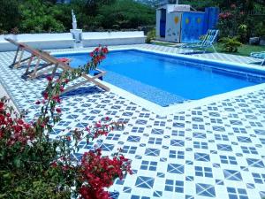TubaráCasa de Campo Palmarito的游泳池设有瓷砖地板和长凳
