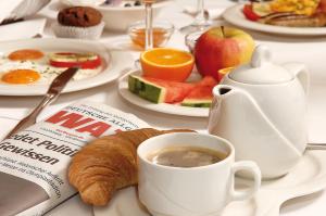 波鸿奥斯特米尔酒店的一张早餐桌,包括一杯咖啡和羊角面包