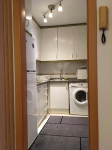 马拉加Appartement à MALAGA的厨房配有白色橱柜、洗衣机和烘干机