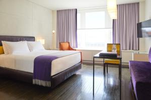 蒙特利尔圣保罗酒店的酒店客房配有一张床、一张书桌和一台电视。
