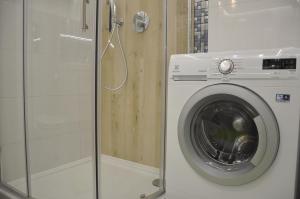 比亚韦斯托克Golden Apartments - City Centrum的带淋浴的浴室内的洗衣机