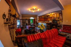 ArkochórionMylos的一间带红色沙发的客厅和一间用餐室