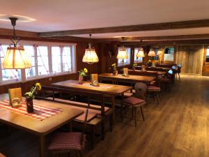 施利尔塞Berggasthof Obere Firstalm的餐厅设有木桌和椅子及灯