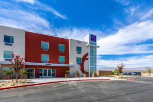 拉斯维加斯Motel 6-Las Vegas, NV - Motor Speedway的拥有红色和白色建筑的酒店,设有停车场