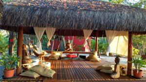 普拉亚多Chalé "Oasis"的一个带枕头的木甲板和茅草屋顶