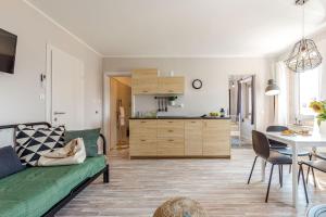 里耶卡Casa San Vito的一间带绿色沙发的客厅和一间厨房
