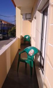 阿尔马达BEM ME QUER 1的两把绿色椅子坐在大楼的阳台上