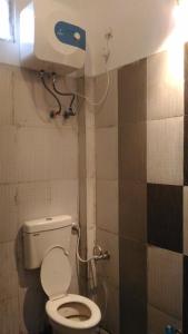 印多尔Ashta Lakshmi Tourist Home Stay的浴室设有卫生间,墙上装有纸浆饮水机