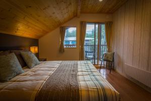白马村白马博德度假屋的一间卧室设有一张带木制天花板的大床