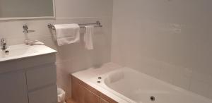 阿沃卡海滩阿沃卡棕榈树酒店的白色的浴室设有浴缸和水槽。