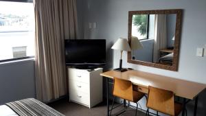 奥克兰外百老汇汽车旅馆的酒店客房配有带电视和镜子的书桌