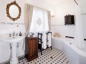 肯图巴库拉拉历史旅馆的白色的浴室设有水槽、浴缸和水槽。