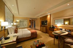钦奈Ramada Plaza Chennai的大型酒店客房,配有一张床和一张书桌
