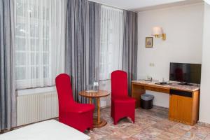 阿尔滕堡阿尔滕堡公园酒店的酒店客房配有红色椅子和书桌