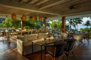 芭东海滩Rosewood Phuket的一间设有桌椅的海景餐厅