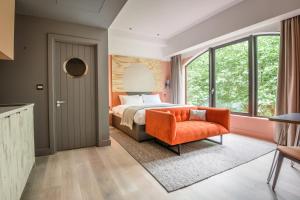 南安普敦room2 Southampton Hometel的一间卧室配有一张床和一张橙色椅子