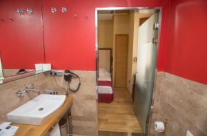 卡塞雷斯唐费尔南多索霍精品酒店的浴室设有水槽、红色墙壁和镜子