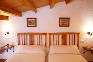 AlbocácerCasa Rural Mas de Sant Pau - Turistrat.的卧室设有2张床和木制天花板。