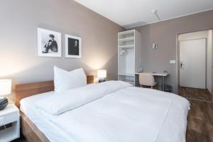 巴塞尔Hotel Birsighof Basel City Center的卧室配有一张白色大床和一张书桌