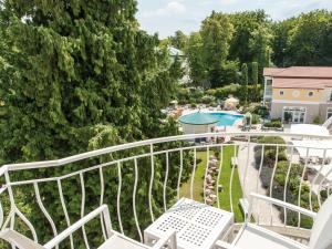 黑灵斯多夫海林斯多夫斯坦迪夏姆旅行酒店的一个带白色椅子的阳台和一个游泳池