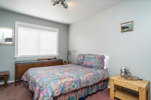 Islandale57 Mud Bay的一间卧室设有一张床、一个窗口和一张桌子