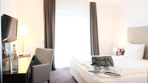 维赫尔泽泊斯特酒店的酒店客房配有一张床、一张书桌和一台电视。