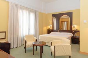 赫雷斯-德拉弗龙特拉Hotel Soho Boutique Jerez的酒店客房带一张床、一张桌子和椅子