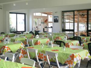 托雷桑塔萨宾娜维拉吉奥拉马福卡露营酒店的宴会厅配有绿色和橙色的桌椅