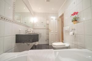 普雷罗Hotel Residenz Rennhack的白色的浴室设有水槽和卫生间。