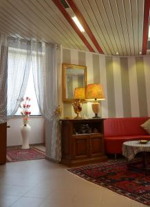 波梅齐亚法西奥尼酒店的客厅配有红色的沙发和镜子